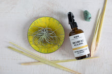 Lem Love Room & Body Mist with lemongrass, crystal and yellow plate with air plant, aerial view.