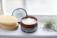 salt scrub by Really Great Goods on windowsill with air plant and body brush